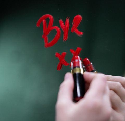 Painting 'bye' in lipstick on a mirror